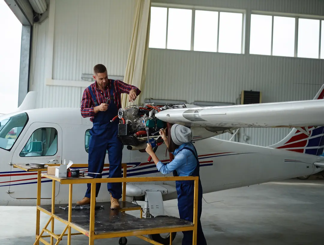 An engineer working on plane for the pilot education loans for pilot training.