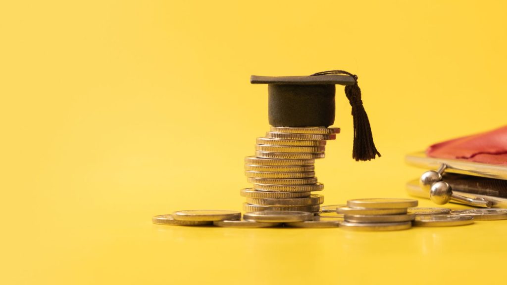 coins stacked with graduation cap