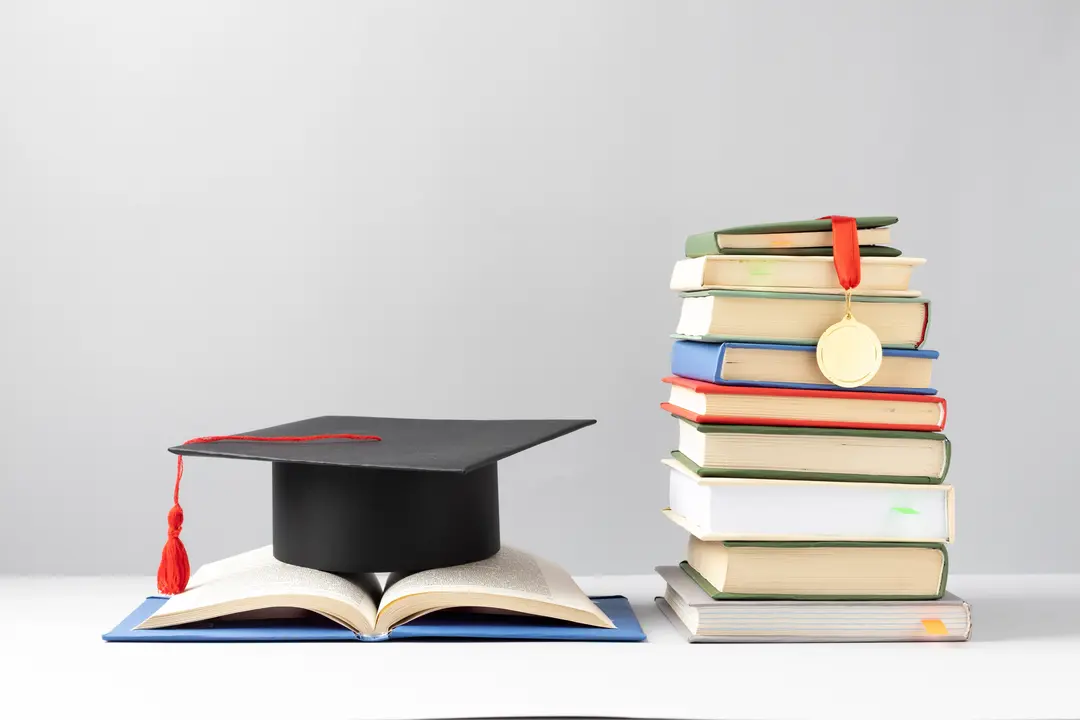 Graduation cap on an open book for a Oxford Brookes University Scholarship